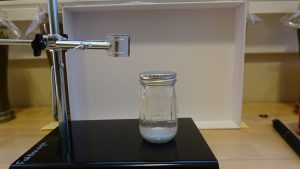 Clear jar in front of a white board
