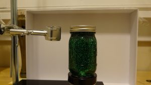 A jar filled with green liquid and green glitter