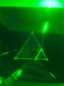 A prism being struck by a green laser